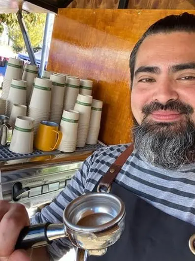 El barista con el portafiltro y los vasos listos