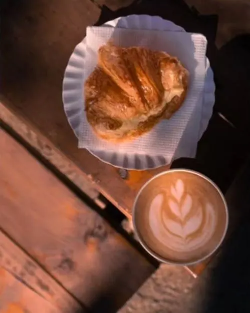 Latte con arte de tulipán y una medialuna
